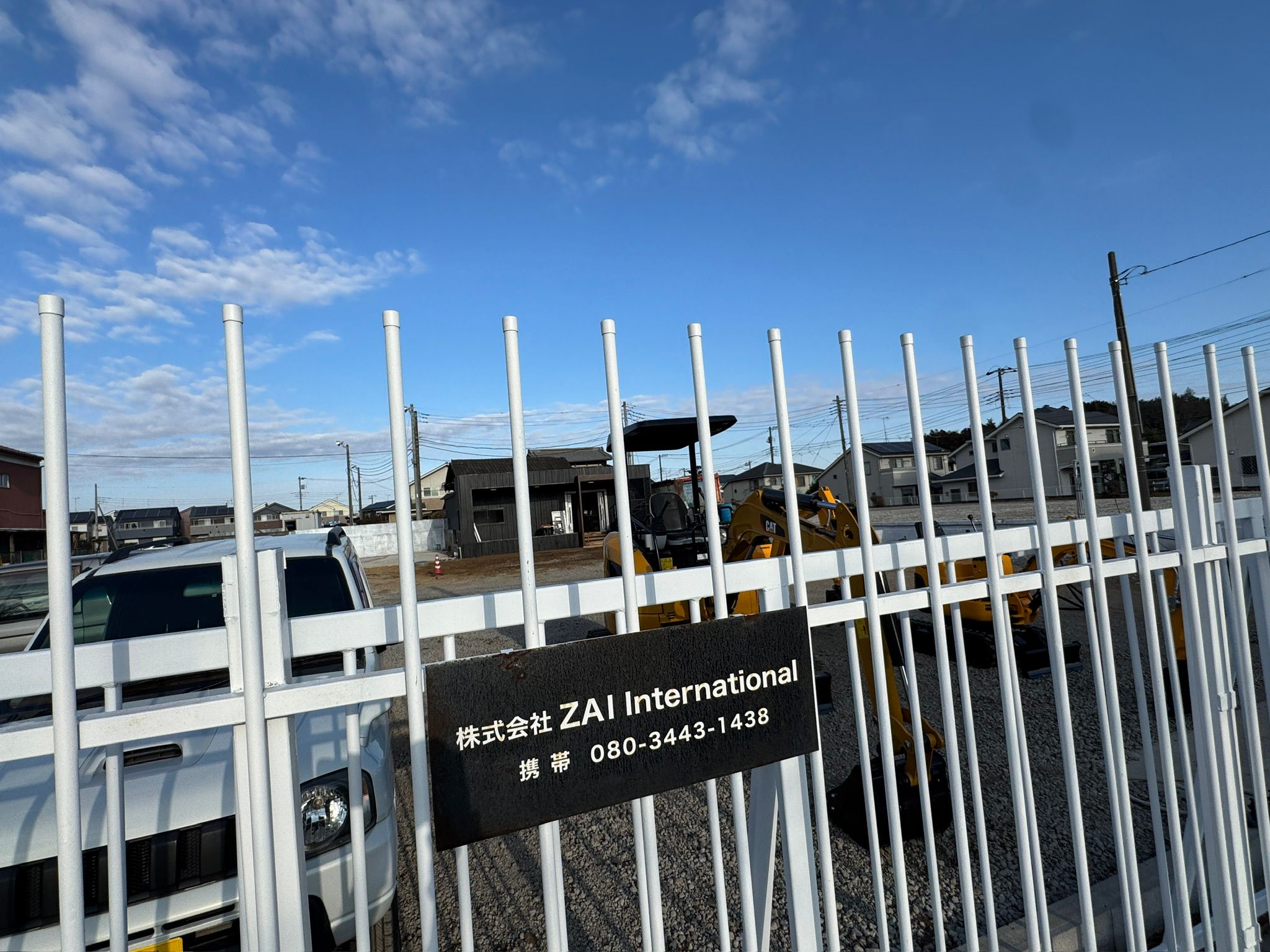 ZAI International白井ヤードの看板と周辺の重機在庫